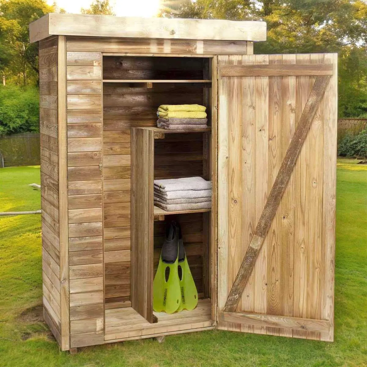 Armoire de jardin en bois brut posée contre un mur de pierre, porte entrouverte laissant voir des outils et des pots en terre cuite