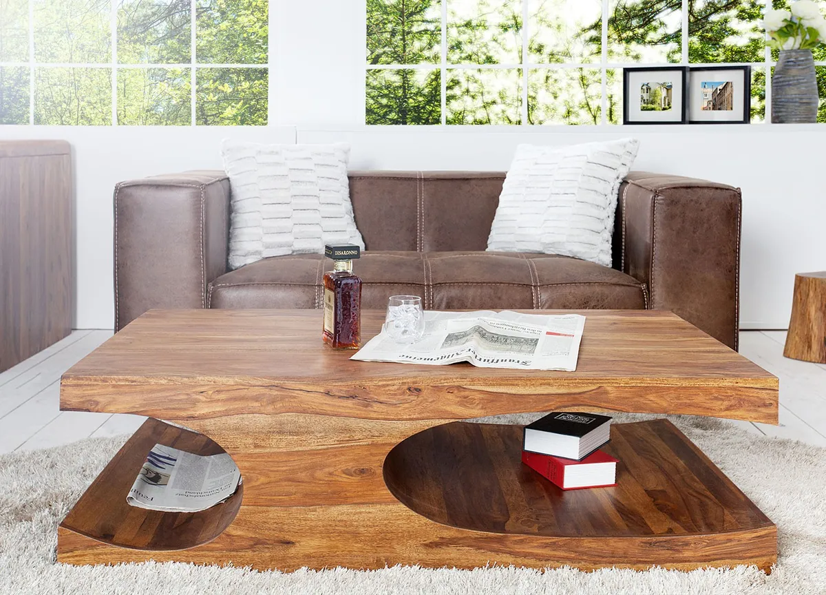 Table basse en chêne massif dans un salon lumineux, plateau à bords légèrement irréguliers, patine douce et pieds en métal noir