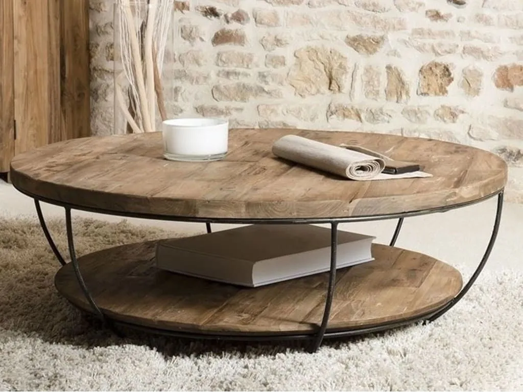 Salon lumineux avec une table basse ronde en bois clair, tapis en laine naturelle et fenêtre donnant sur un jardin breton